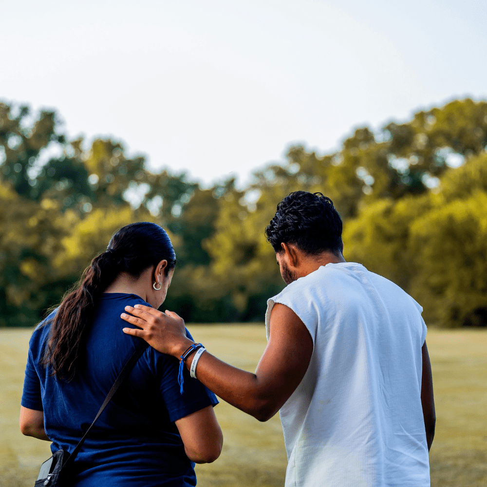 2 people in open field chatting 