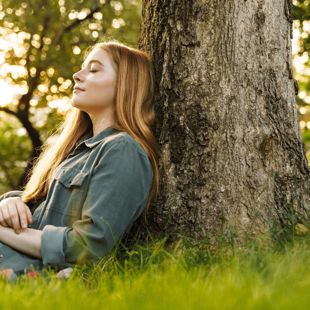 person leaning on tree