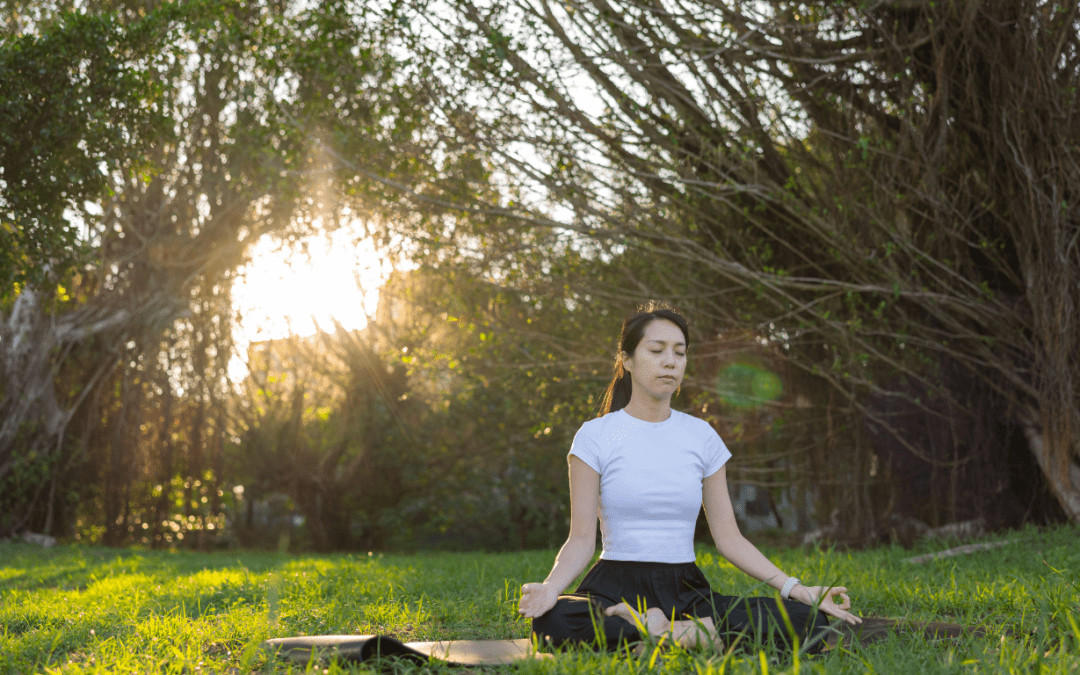 person meditating in grass field