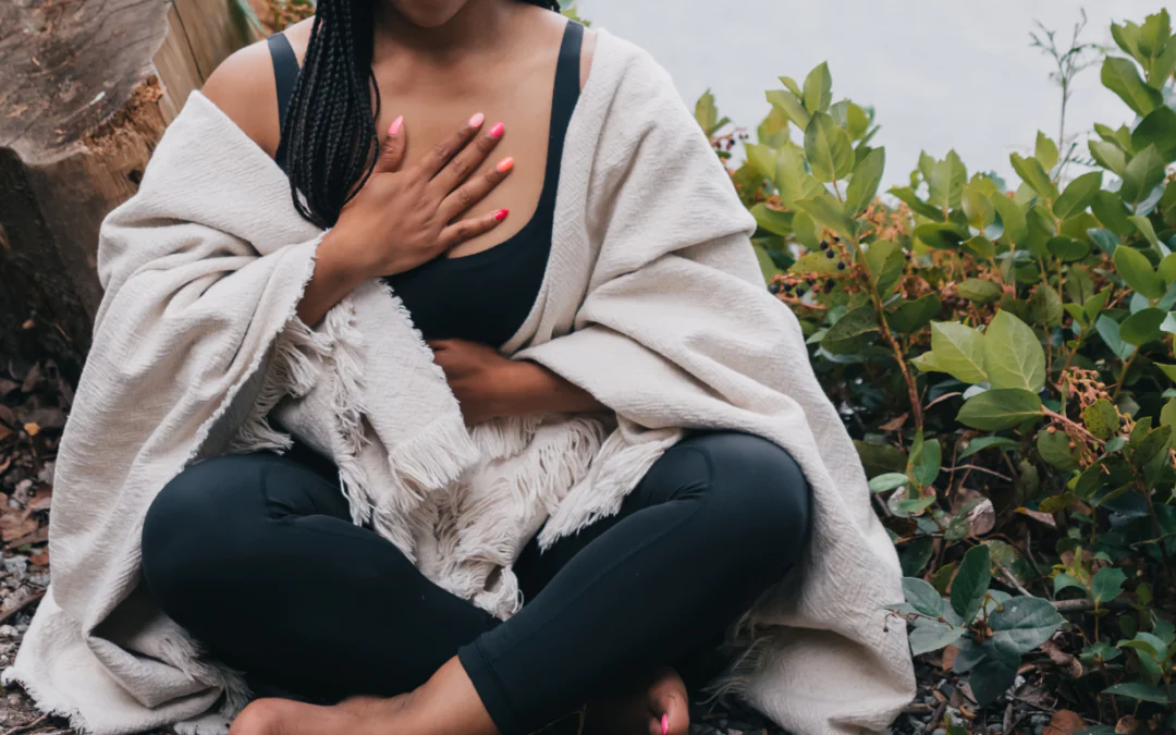 woman taking a moment to meditate and drop into her body in nature